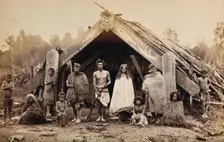 New Zealand: a group of Maori in front of a traditional building, 19th century. Creator: Unknown