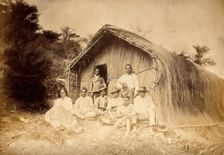 New Zealand: a group of Maori sitting in front of a traditional house, between 1800 and 1899. Creator: Unknown