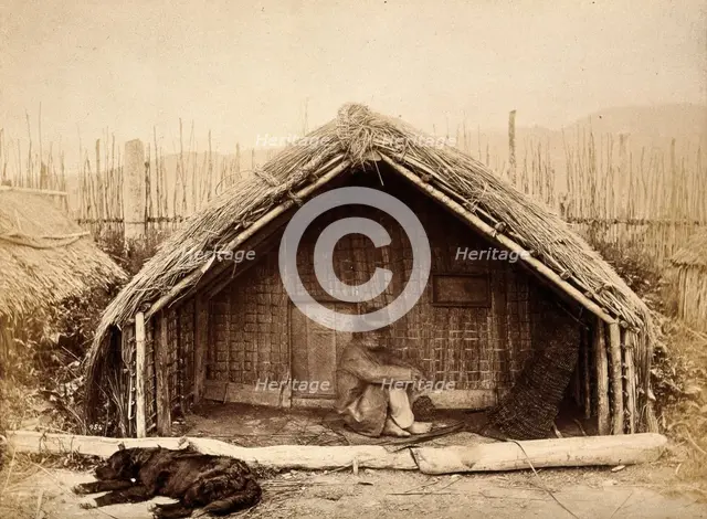 New Zealand: a Maori man sitting in front of a traditional house, between 1800 and 1899. Creator: Unknown.