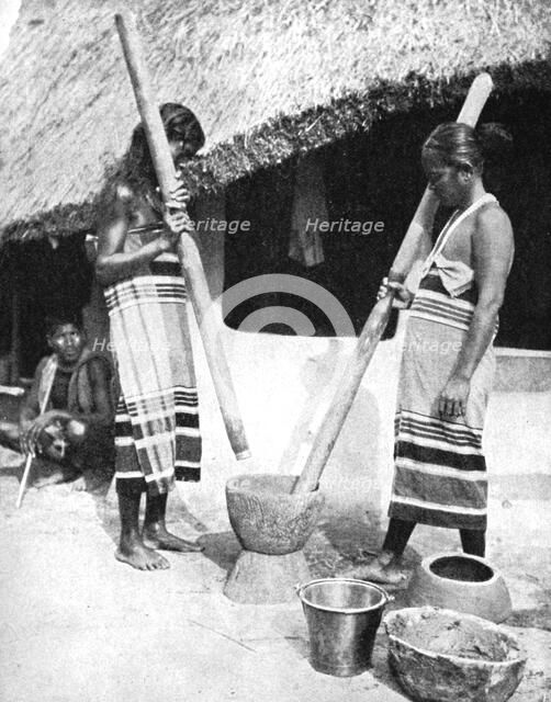 Newar women pounding grain, Nepal, 1936.Artist: Ewing Galloway