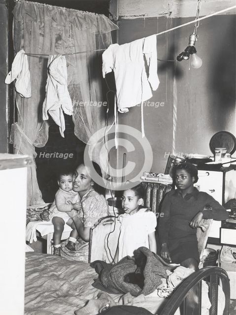 Negro family living in crowded quarters, Chicago, Illinois, April 1941. Creators: Farm Security Administration, Russell Lee.
