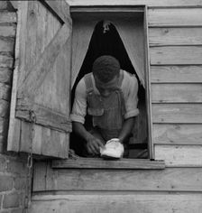 Negro field hand getting ready to go to town on a Saturday afternoon, 1937. Creator: Dorothea Lange