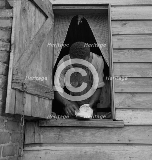 Negro field hand getting ready to go to town on a Saturday afternoon, 1937. Creator: Dorothea Lange.