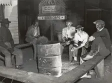 Negro laborers sitting around in front of a fire on Saturday night in a street of the..., Feb 1941. Creators: Farm Security Administration, Marion Post Wolcott