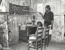 Negro mother teaching children numbers and alphabet in home of sharecropper..., Jan 1939. Creators: Farm Security Administration, Russell Lee