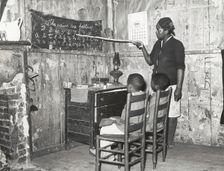 Negro mother teaching children numbers and alphabet in home of sharecropper..., Jan 1939. Creators: Farm Security Administration, Russell Lee