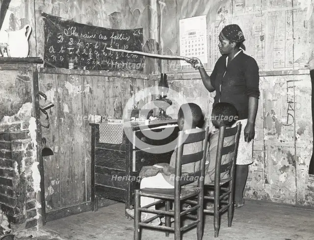 Negro mother teaching children numbers and alphabet in home of sharecropper..., Jan 1939. Creators: Farm Security Administration, Russell Lee.