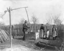 Negro man, woman and three children at an old-time well, 1899 or 1900. Creator: Frances Benjamin Johnston