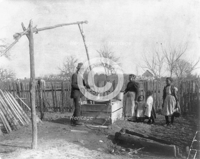 Negro man, woman and three children at an old-time well, 1899 or 1900. Creator: Frances Benjamin Johnston.