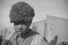 Negro with a fur cap, a flood refugee in the camp at Forrest City, Arkansas, 1937. Creator: Walker Evans