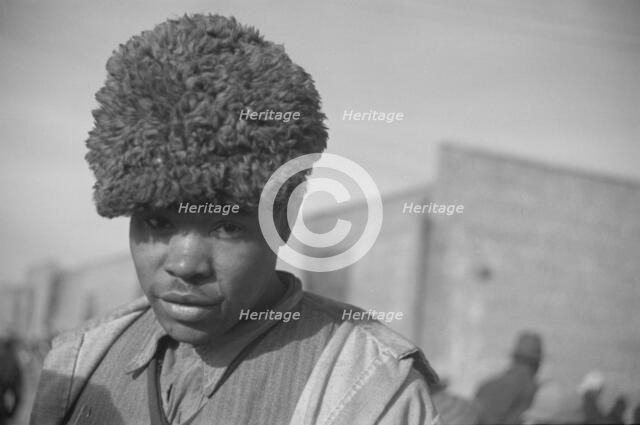 Negro with a fur cap, a flood refugee in the camp at Forrest City, Arkansas, 1937. Creator: Walker Evans.