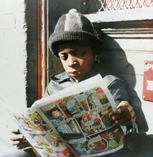 Negro youth reading a funny paper on a door step in the Southwest section, Washington, D.C., 1942. Creator: Gordon Parks
