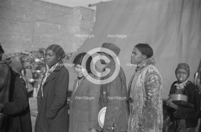 Negroes at mealtime in the flood refugee camp, Forrest City, Arkansas, 1937. Creator: Walker Evans.