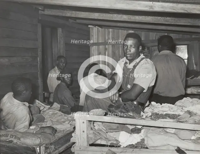 Negroes in bunkhouse in strawberry fields near Hammond, Louisiana; Note crude..., April 1939. Creators: Farm Security Administration, Russell Lee.
