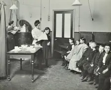 Nurse cutting children's verminous hair, Finch Street Cleansing Station, London, 1911