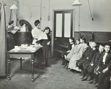 Nurse cutting children's verminous hair, Finch Street Cleansing Station, London, 1911