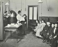 Nurse cutting children's verminous hair, Finch Street Cleansing Station, London, 1911
