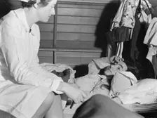 Nurse attending sick migrant woman, FSA camp, Farmersville, Tulare County, California, 1939. Creator: Dorothea Lange