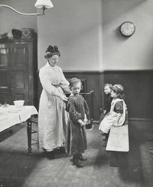 Nurse examining children before cleansing Chaucer Cleansing Station, London, 1911