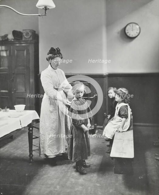 Nurse examining children before 'cleansing', Chaucer Cleansing Station, London, 1911. Artist: Unknown.