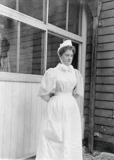 Nurse standing outside an isolation hospital, possibly at Ilford, Essex. Creator: Unknown