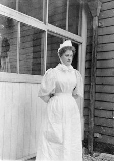 Nurse standing outside an isolation hospital, possibly at Ilford, Essex. Creator: Unknown