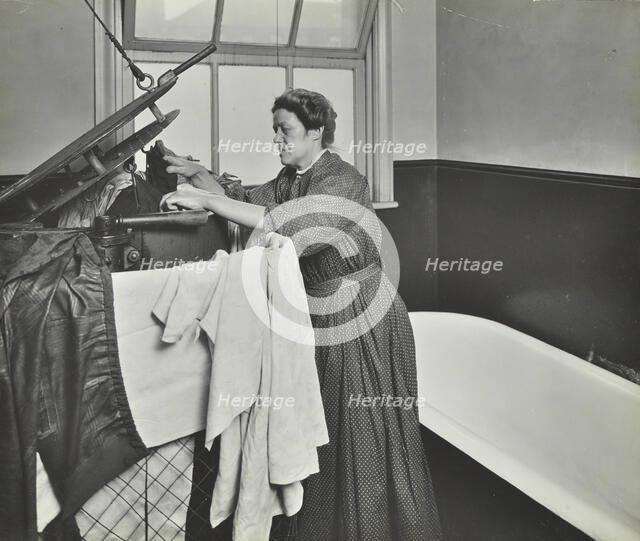 Nurse using a steriliser in the bathroom at Chaucer Cleansing Station, London, 1911. Artist: Unknown.