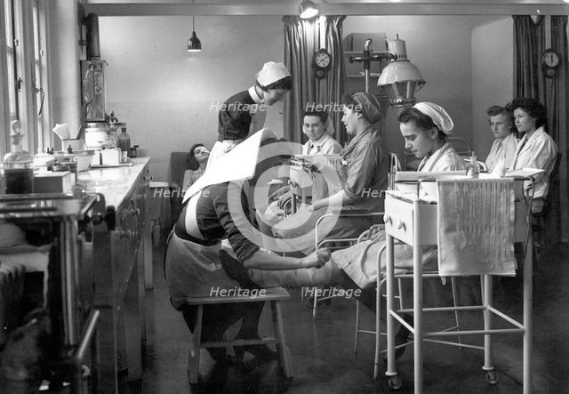 Nurses attend to staff in the Rowntree factory surgery, York, Yorkshire, 1946. Artist: Unknown