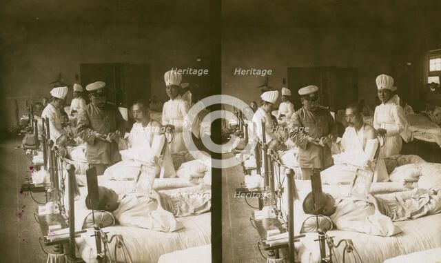 Nurses and a doctor attending wounded soldiers on a hospital ward, c1905. Creator: Underwood & Underwood.