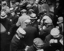 Small Crowd of Men Standing Outside in a Crowded Space, 1933. Creator: British Pathe Ltd