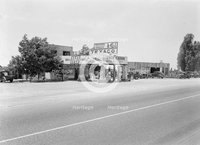 Small independent gas stations litter the highway, near Kingsburg, California, 1939. Creator: Dorothea Lange.