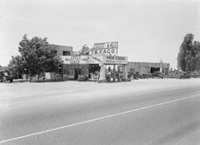 Small independent gas stations litter the highway, near Kingsburg, California, 1939. Creator: Dorothea Lange