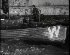 Small Wooden Customs Boat With Male Crew Member Standing at the Bow End Alongside..., 1939. Creator: British Pathe Ltd