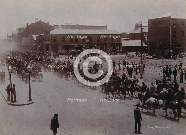 South Africa: Boer soldiers riding through a street in a South African town, 1896. Creator: Barnett.