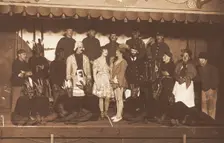 Soldiers, some in drag, pose on stage; two men in drag face each other in the centre, [1910-1919?]. Creator: Unknown