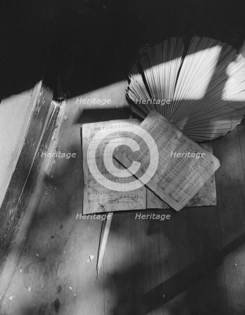 Song sheets and a fan left behind in an abandoned church on Independence Ave, Washington, D.C, 1942. Creator: Gordon Parks.