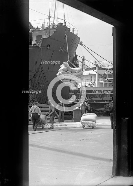 Sacks being loaded onto a ship in London docks, c1945-c1965. Artist: SW Rawlings