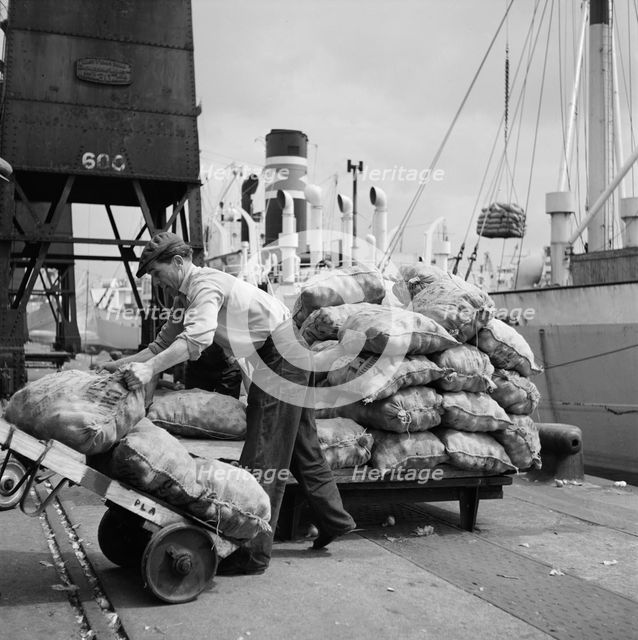 Sacks of vegetables being loaded onto a ship in London docks, c1945-c1965. Artist: SW Rawlings