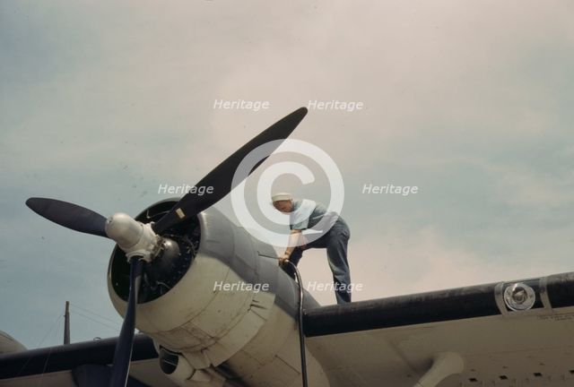 Sailor mechanic fueling a plane at the Naval Air Base, Corpus Christi, Texas, 1942. Creator: Howard Hollem.