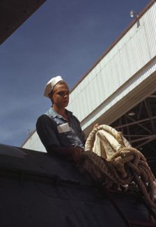 Sailor mechanic inspecting a PBY plane at the Naval Air Base, Corpus Christi, Texas, 1942. Creator: Howard Hollem