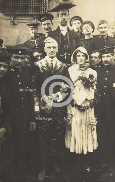 Sailors on HS Dominion, one in bridal drag, conduct a mock wedding on Christmas Day, 1915. Creator: Unknown.