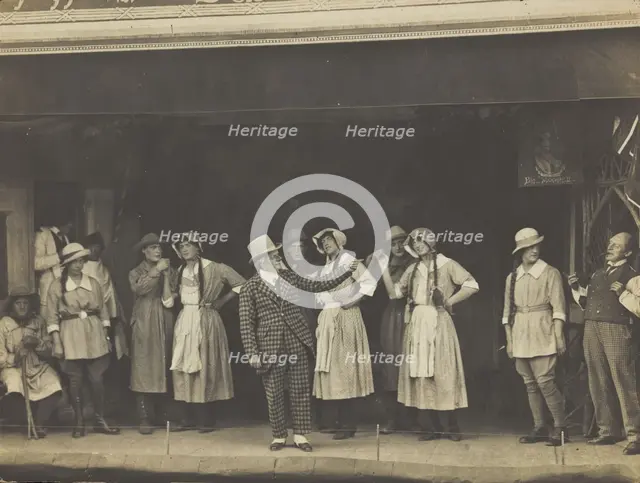 Sailors, some in drag, stand on stage performing a scene, (between 1910 and 1919?). Creator: Unknown.