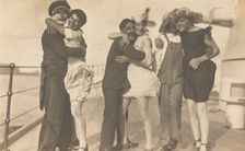 Sailors, some in drag, pose as three couples on the deck of a ship, (between 1920 and 1929?). Creator: Unknown