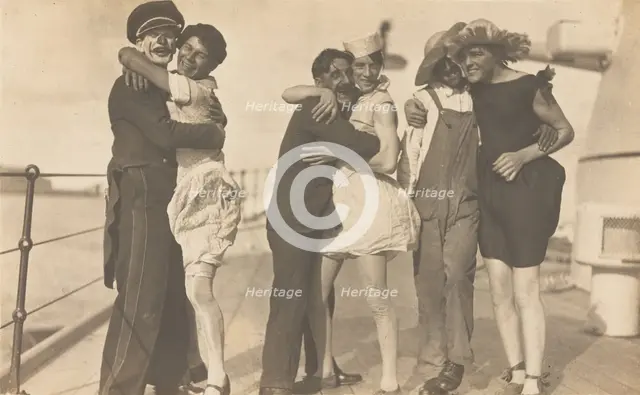 Sailors, some in drag, pose as three couples on the deck of a ship, (between 1920 and 1929?). Creator: Unknown.