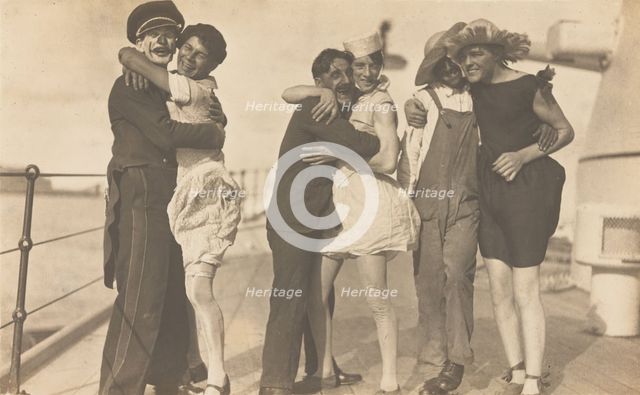 Sailors, some in drag, pose as three couples on the deck of a ship, (between 1920 and 1929?). Creator: Unknown.
