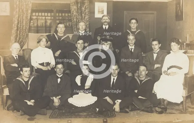 Sailors, some in drag, posing for a group portrait within a highly...(between 1910 and 1919?). Creator: Unknown.