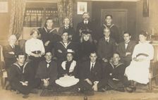 Sailors, some in drag, posing for a group portrait within a highly...(between 1910 and 1919?). Creator: Unknown