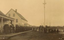 Sailors standing in line on boardwalk with a group of local women and men standing..., 1894 or 1895. Creator: Alfred Lee Broadbent