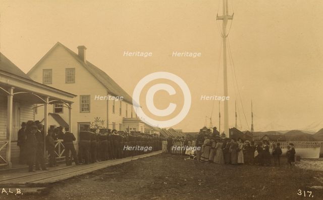 Sailors standing in line on boardwalk with a group of local women and men standing..., 1894 or 1895. Creator: Alfred Lee Broadbent.