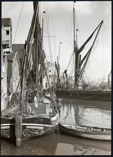 Sailed fishing vessels moored beside timber warehouses at Rochester, Medway, 1925-1935. Creator: J Dixon Scott